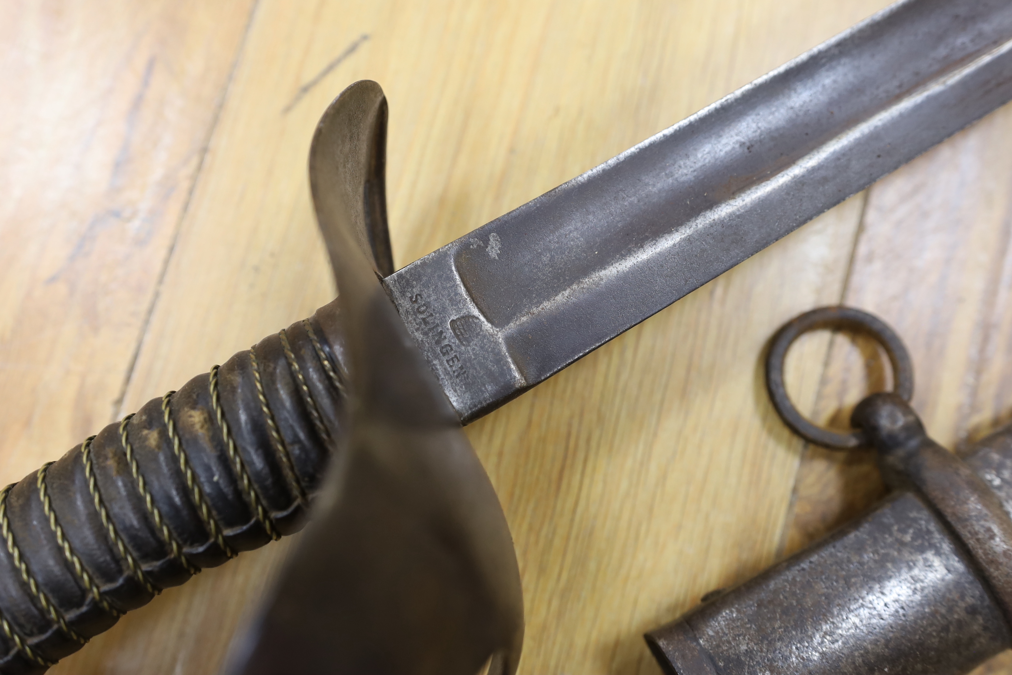 A pair of late 19th century German swords, one in its scabbard, together with another unrelated scabbard, made for the international arms trade, probably in Solingen, blade 89cm. Condition - fair, scabbards are 87cm and